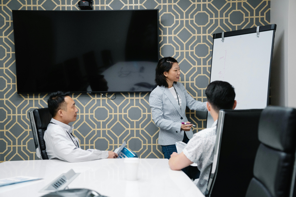 pexels photo 7964144 7964144 A professional conducting a presentation in a modern office space with colleagues engaged.